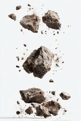 Three dark gray rocks suspended in mid-air, surrounded by smaller fragments of rock and dust, against a white background