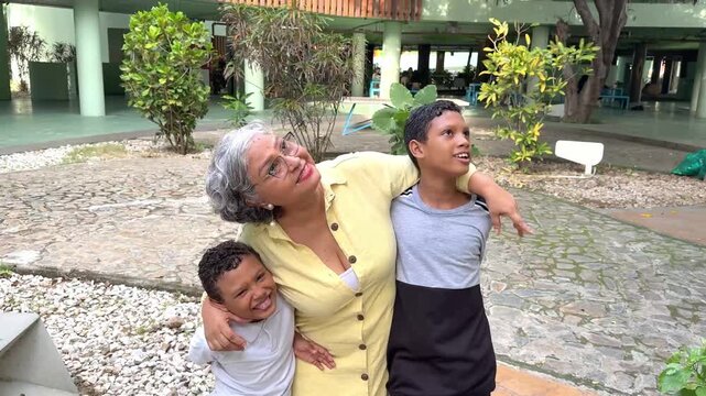 Grandmother and grandchildren looking up, sharing a moment of complicity