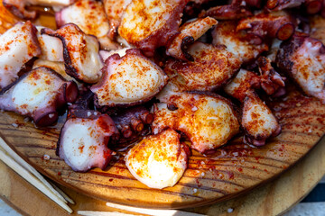 A close up of a traditional wooden plate of Galician style octopus The Best of Spanish Gastronomy