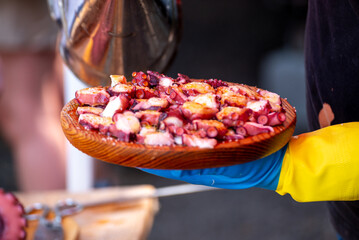 A chef serving a traditional plate of Galician style octopus, Spanish Cuisine