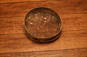 Antique flour sieve on wooden table