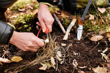 Senior woman demonstrates fire starting skills while hiking in a beautiful forest environment