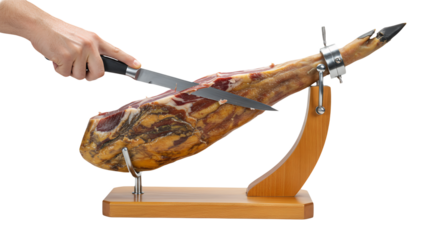 Chef’s hand holding a carving knife about to slice premium Iberico Ham leg on wooden stand, transparent background
