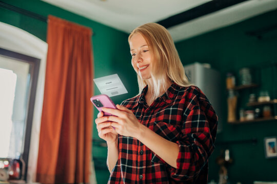 Smiling person verifying identity on smartphone at home