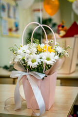 Bouquets brought as a gift to the teacher are on the desks of the students.