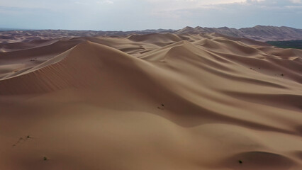 Aerial view of sand dunes in desert at sunset