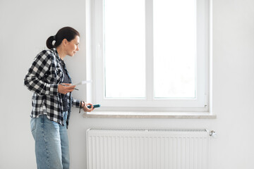 Girl Measures The Window For The Blinds Using A Laser Measure
