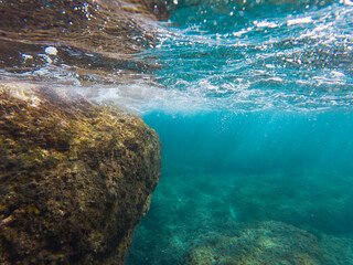 An immersive action camera perspective of the sunlit underwater seascape off the coast of France, a prime spearfishing location.