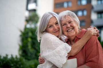 Portrait of beautiful adult daughter with old mother.