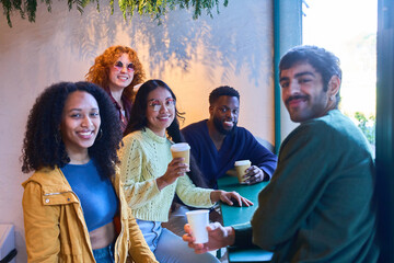 Group of diverse friends enjoying coffee together in cafe