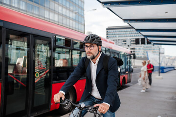 City commuter riding bike to office, wearing backpack and helmet.