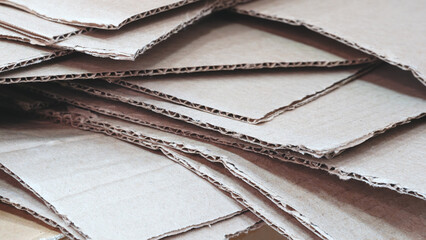 Pile of cardboard boxes stacked on top of each other. The boxes are all different sizes and shapes, but they all have a similar texture and color. Concept of clutter and disorganization