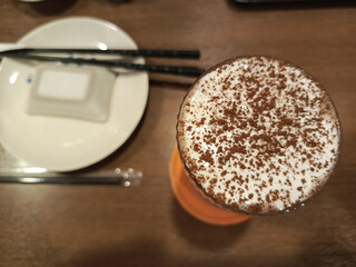 Artful Top-Down View of a Frothy Cocoa Drink in a Cozy Asian Restaurant Setting