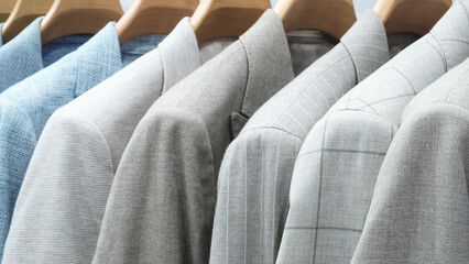 Fototapeta premium A row of clothes hanging on a hanger, the clothes are of different colors and textures, and all neatly folded. The concept of organization and order. Clothing sale concept background.