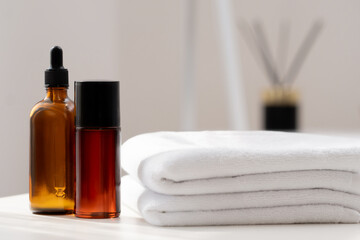 Bottles of essential oils and soft towels arranged neatly in a tranquil spa setting