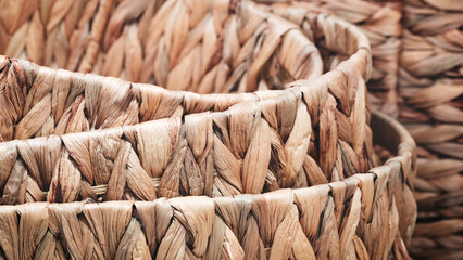 Close up of a woven basket with a brown and tan color. The basket is made of straw and has a rustic...