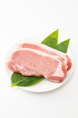 皿に乗った豚ロース肉　白バック