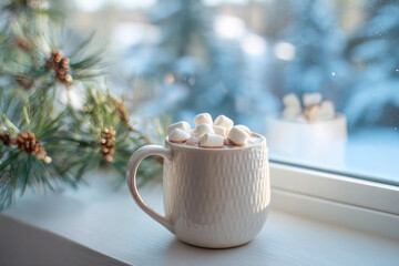 Realistic photo of white ceramic mug with hot cocoa and marshmallows on windowsill with winter background and pine branch in soft morning light