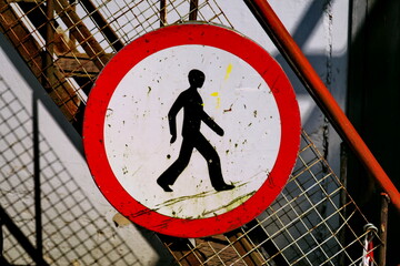 Pictogramme noir représentant un piéton en marche, inscrit dans un cercle rouge. Panneau d'interdiction: aux piétons de pénétrer dans une zone.
