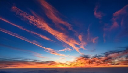 Fototapeta premium Fire On The Sky From High Above Far Sunset And Orange And Red Colored Streakes Of Cirrus Clouds On Deep Blue Evening Sky Ideal For Sky Replacement Projects No Obstacles In The Front