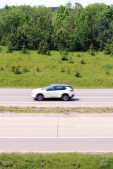 Freedom and travel on the open summer road, motion blur car driving on highway through green nature