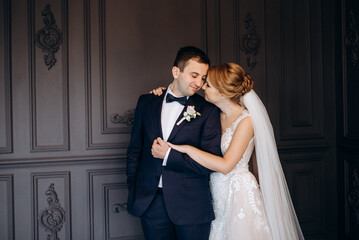 young couple bride and groom in a dark studio with a floor mirror