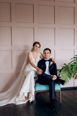 Fototapeta premium young couple bride and groom in a dark studio with a floor mirror