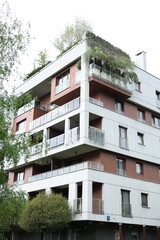 Modern apartment building with green roof, glass balconies