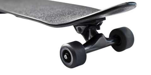Close up of a black skateboard deck and trucks on a black background