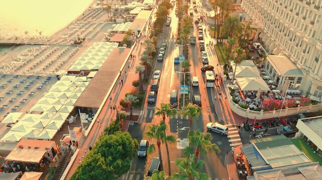Drone flying over streets of Cannes capturing transportation during sunset in France.