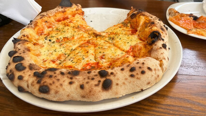Wood-fired pizza served on a white plate.