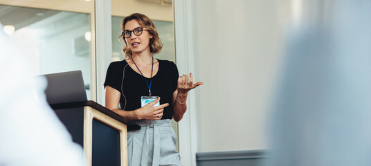 Fototapeta na wymiar Woman speaking at business conference with presentation