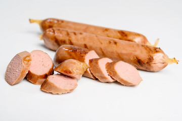 Slices of fried grilled sausage isolated over a white background. Oktoberfest festival