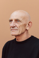 Obraz premium elderly man with blank stare stands against clean tonal background evoking deep emotions