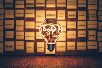 A glowing light bulb at the center with sticky notes in the background represents ideas, inspiration, problem-solving, and brainstorming.