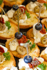 Canapes with feta cheese olives blueberry tomato on bread base