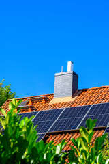 Roof of a residential building with chimney and photovoltaic system.