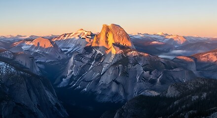 Stunning sunrise illuminates Half Dome and Yosemite Valley with golden light painting majestic granite peaks and misty depths