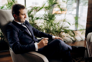 portrait of groom in blue tuxedo in hotel