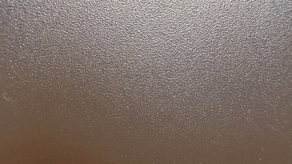 metallic bronze pebble grain surface texture macro with shimmering light reflection for modern wallpaper or elegant commercial background