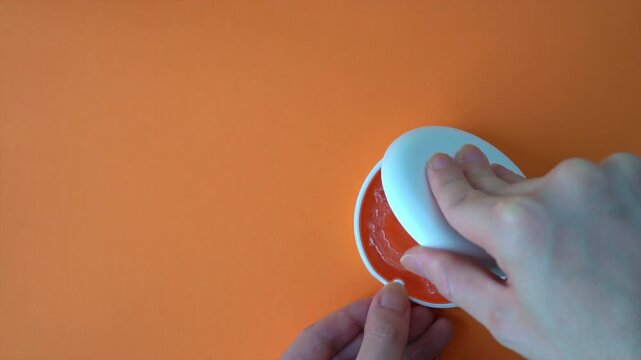  Opening White and Orange Dental Aligner Case that are Orthodontic Mouthpiece storage in orange background. Slow motion. copy space.