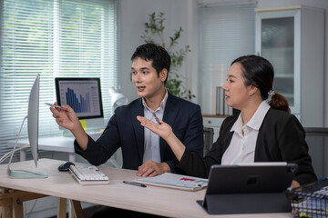 Business people discussing work using computer in office