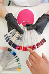 A variety of nail polish colors displayed on swatches, allowing clients to choose their desired shade for a manicure