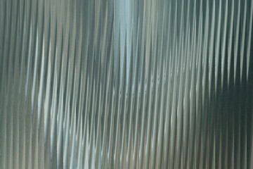 The textured surface of corrugated metal sheeting displays a pattern of vertical ridges with subtle...