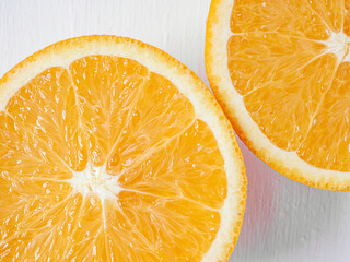 Halved orange fruit on white wooden background, close-up