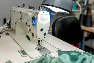 A close-up of a sewing machine in action, illustrating craftsmanship and creativity in textile production and fashion design. a seamstress's workplace with a sewing machine in a sewing workshop