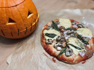 Halloween table. Homemade pizza with mushroom skulls baked in the oven. High quality photo