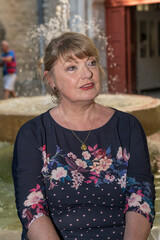femme assise devant une fontaine, portrait d'une belle femme retraitée