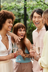 Happy friends enjoying laughter and drinks at an outdoor cafe during a sunny day