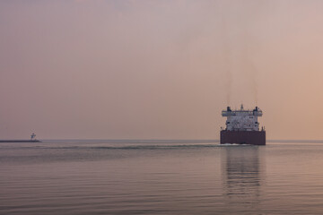A Ship Leaving A Harbor On Lake Superior On A Wildfire Smokey Hazy Evening